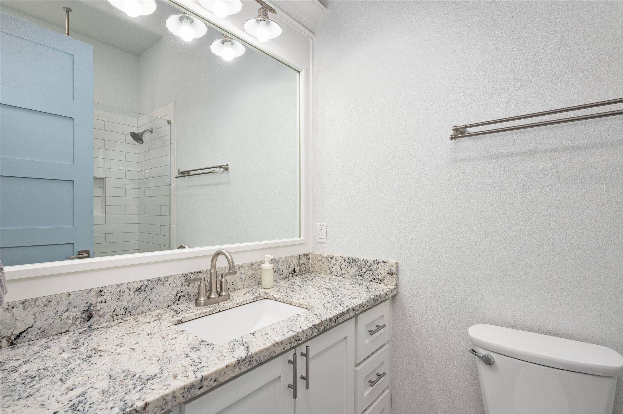 997 South Redfish Crystal Beach, TX 77650 - Photo 18 of 45 a bathroom with a granite countertop sink a toilet and a mirror