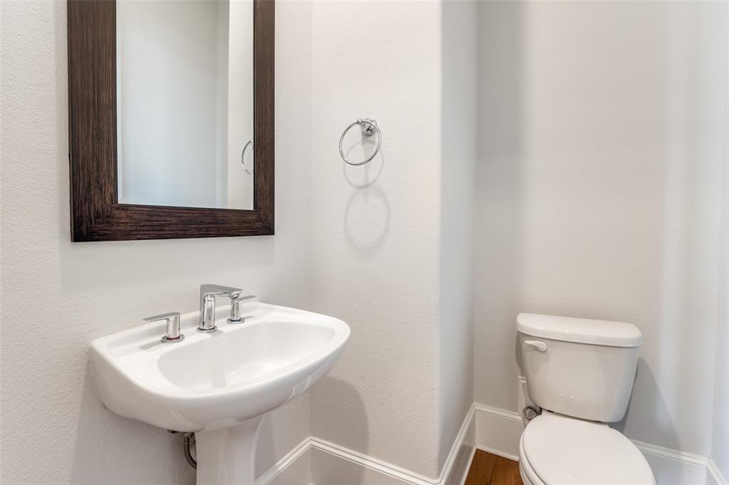 5421 Patterson Street Irving, TX 75039 - Photo 27 of 32 Pedestal sink with chrome fixtures, framed mirror, and white toilet