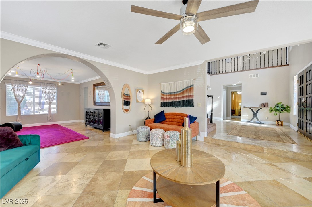 1486 Powder Horn Drive Henderson, NV 89014 - Photo 11 of 99 Living room featuring ornamental molding, a ceiling fan, and arched walkways
