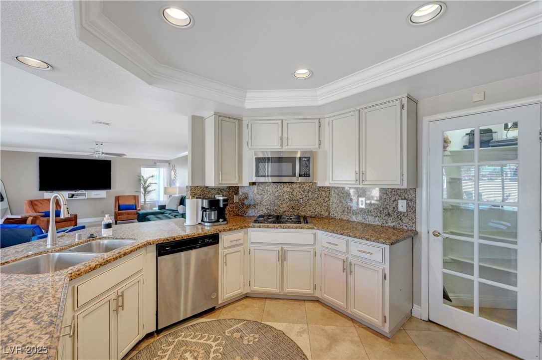 1486 Powder Horn Drive Henderson, NV 89014 - Photo 97 of 99 Kitchen featuring ornamental molding, open floor plan, a tray ceiling, stainless steel appliances, and recessed lighting