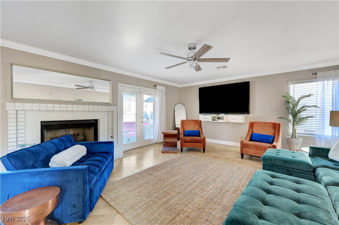 1486 Powder Horn Drive Henderson, NV 89014 - Photo 33 of 99 Tiled living area with crown molding, ceiling fan, a fireplace, and french doors