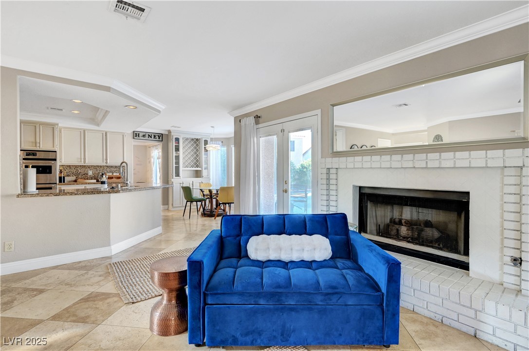 1486 Powder Horn Drive Henderson, NV 89014 - Photo 37 of 99 Living area with ornamental molding, a fireplace, light tile patterned floors, and recessed lighting
