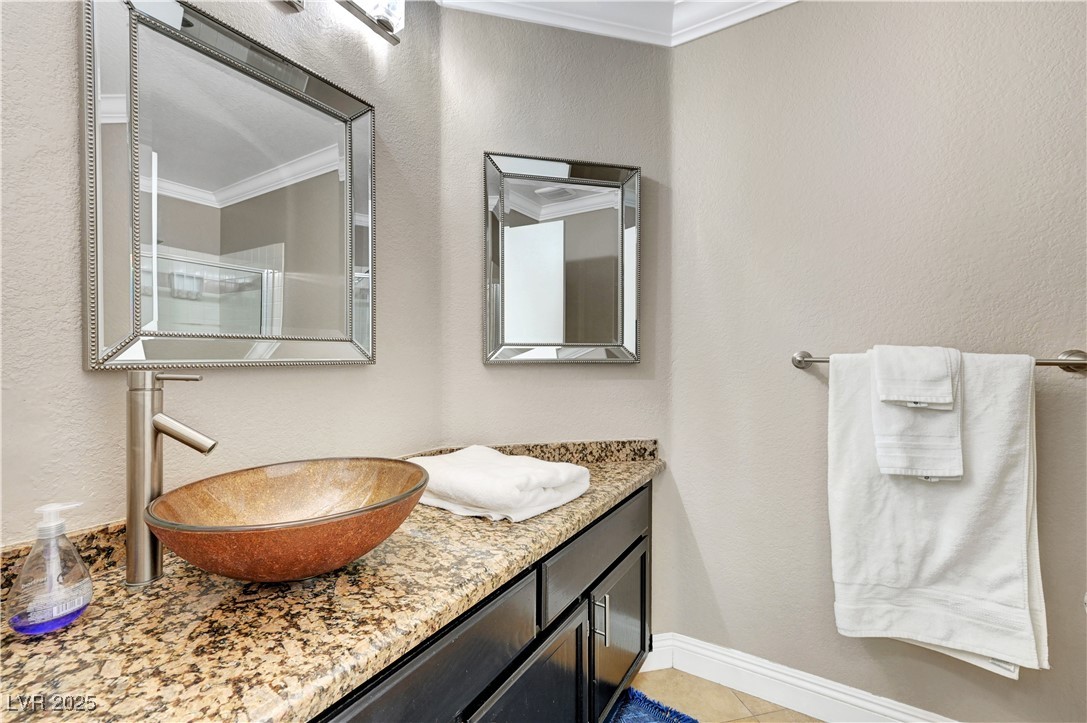 1486 Powder Horn Drive Henderson, NV 89014 - Photo 39 of 99 Full bath with a textured wall, crown molding, vanity, a shower stall, and light tile patterned flooring