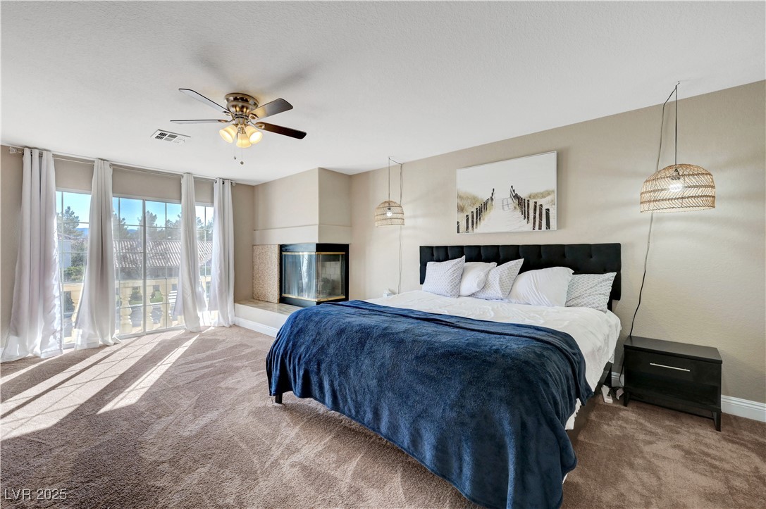 1486 Powder Horn Drive Henderson, NV 89014 - Photo 48 of 99 Bedroom with carpet flooring, a ceiling fan, a wall of windows, and access to exterior