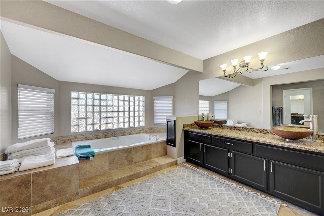 1486 Powder Horn Drive Henderson, NV 89014 - Photo 53 of 99 Full bath with double vanity, plenty of natural light, a bath, and light tile patterned flooring