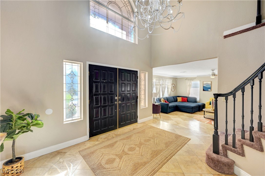 1486 Powder Horn Drive Henderson, NV 89014 - Photo 6 of 99 Foyer featuring stairs, a high ceiling, light tile patterned floors, and a chandelier