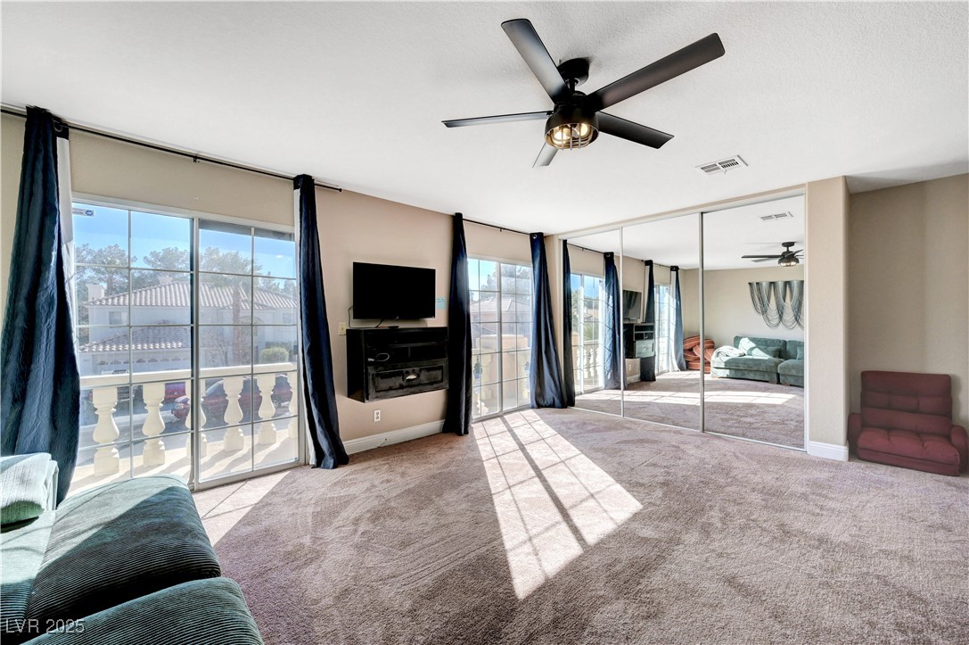 1486 Powder Horn Drive Henderson, NV 89014 - Photo 76 of 99 Bedroom featuring access to exterior, light colored carpet, a wall of windows, a ceiling fan, and a closet