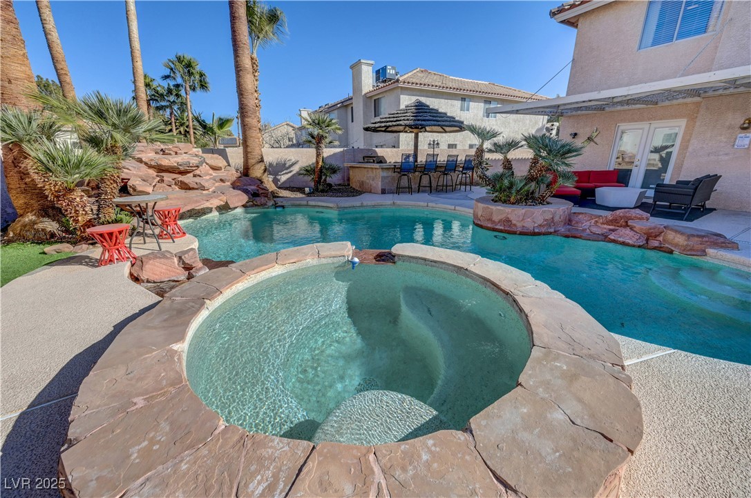 1486 Powder Horn Drive Henderson, NV 89014 - Photo 91 of 99 View of swimming pool featuring a pool with connected hot tub, a patio, and an outdoor living space