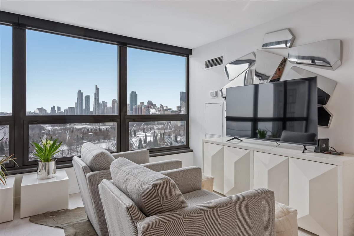 360 East Randolph Street, Unit 1002 Chicago, IL 60601 - Photo 14 of 27 a living room with furniture and a floor to ceiling window
