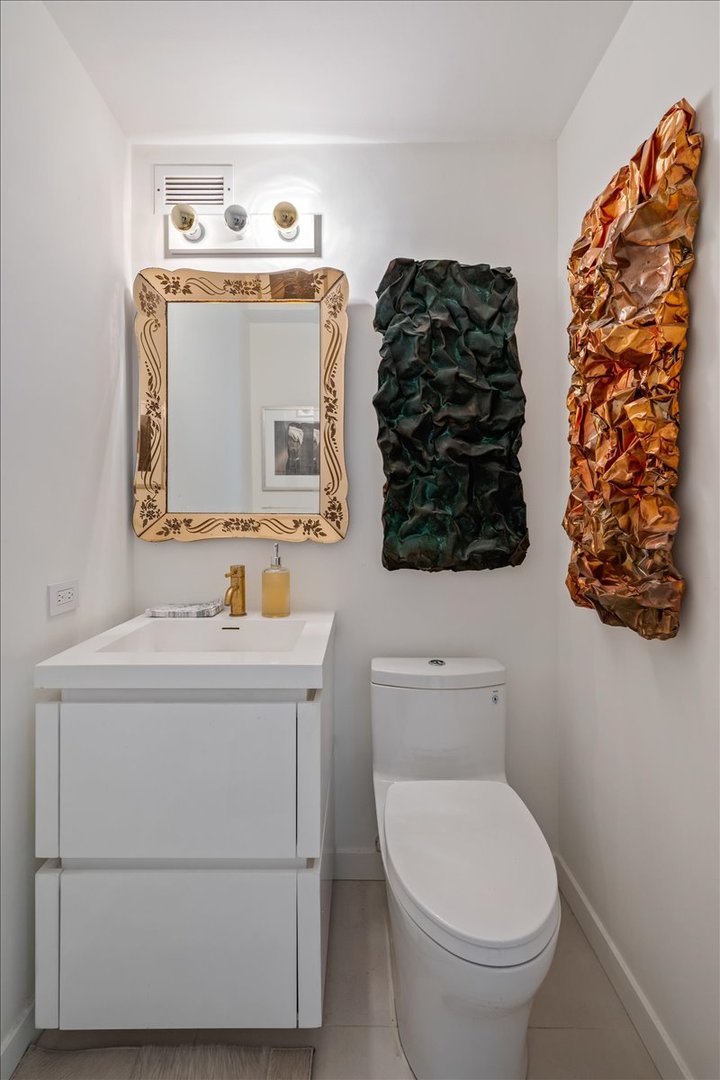 360 East Randolph Street, Unit 1002 Chicago, IL 60601 - Photo 21 of 27 a bathroom with a toilet sink and mirror