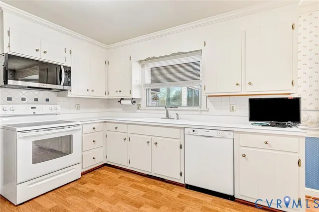 a kitchen with cabinets stainless steel appliances a sink and a window