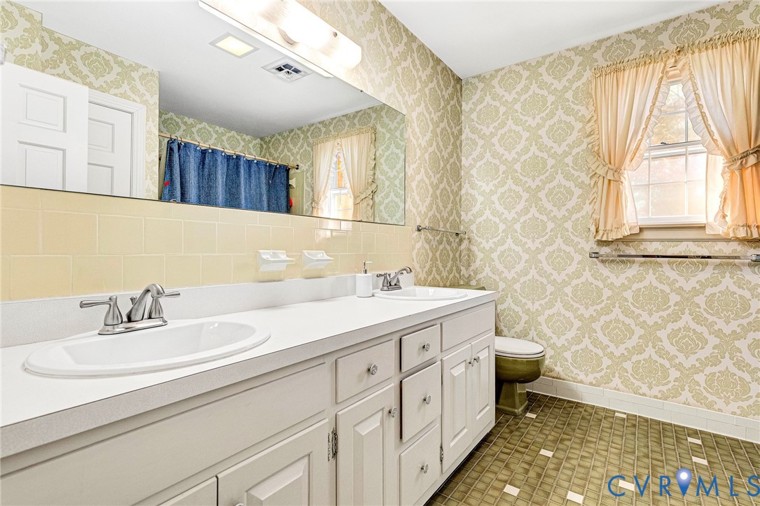 2820 Euphoria Road Chester, VA 23831 - Photo 30 of 38 Full bathroom with wallpapered walls, double vanit