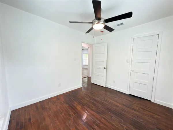 a view of an empty room with wooden floor