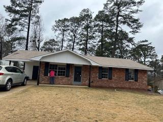 a view of a house with a barbeque and large tree
