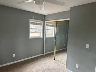 a view of an empty room with window and closet area