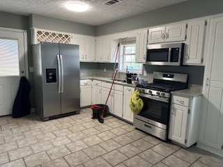 6229 Potomac Circle Columbus, GA 31909 - Photo 5 of 14 a kitchen with stainless steel appliances granite countertop a stove a refrigerator and a microwave