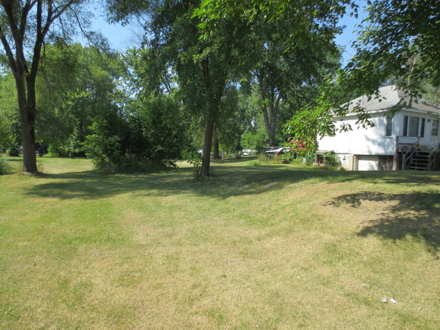 26211 West Rollins Road Ingleside, IL 60041 - Photo 1 of 16 a view of a yard with table and chairs and large trees