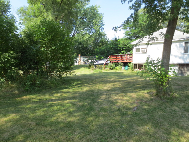 26211 West Rollins Road Ingleside, IL 60041 - Photo 4 of 16 a backyard of a house with table and chairs plants and large trees