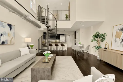 a living room with furniture stairs and a potted plant