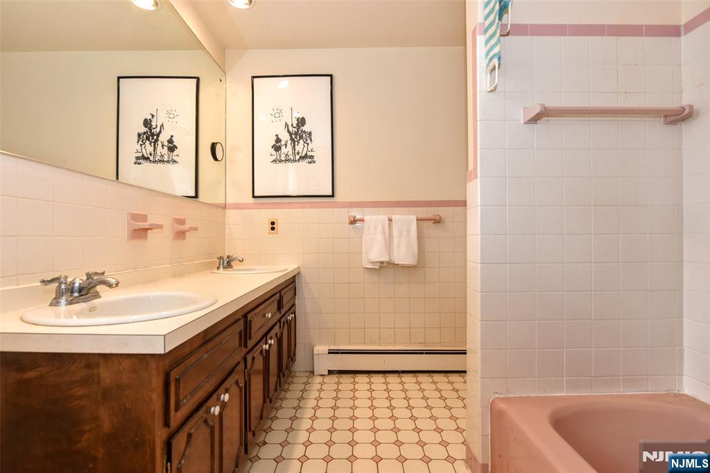 951 Berdan Avenue Wayne, NJ 07470 - Photo 18 of 39 a bathroom with a sink a mirror and a bathtub