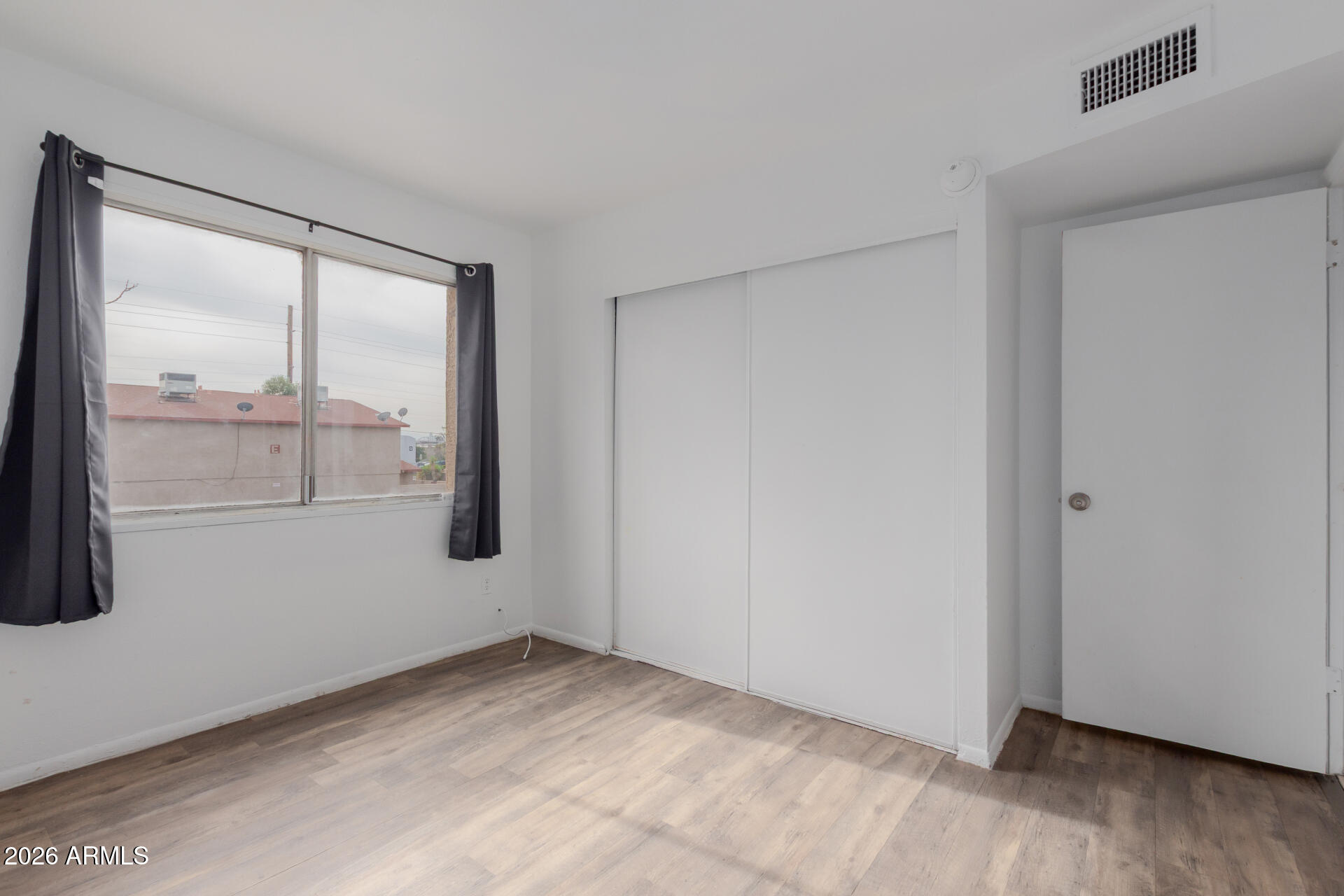 4002 West Palomino Road Phoenix, AZ 85019 - Photo 15 of 23 a view of an empty room with wooden floor and a window