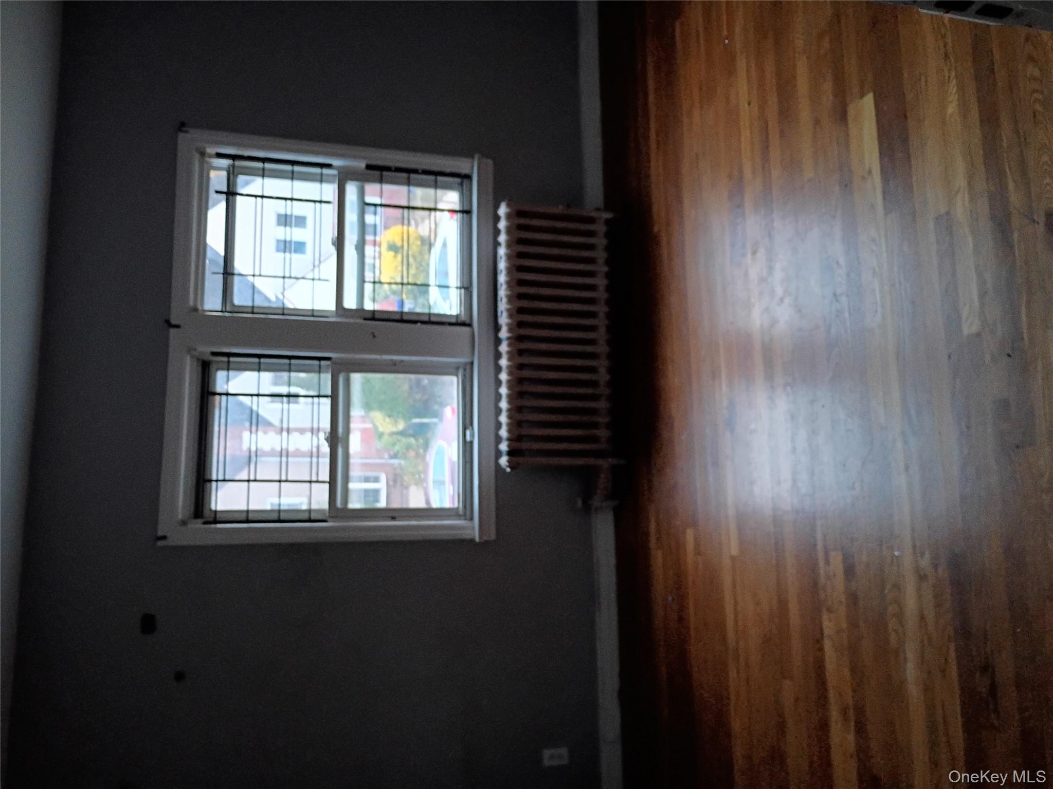115-40 227th Street Queens, NY 11411 - Photo 9 of 9 a view of an empty room with wooden floor and a window