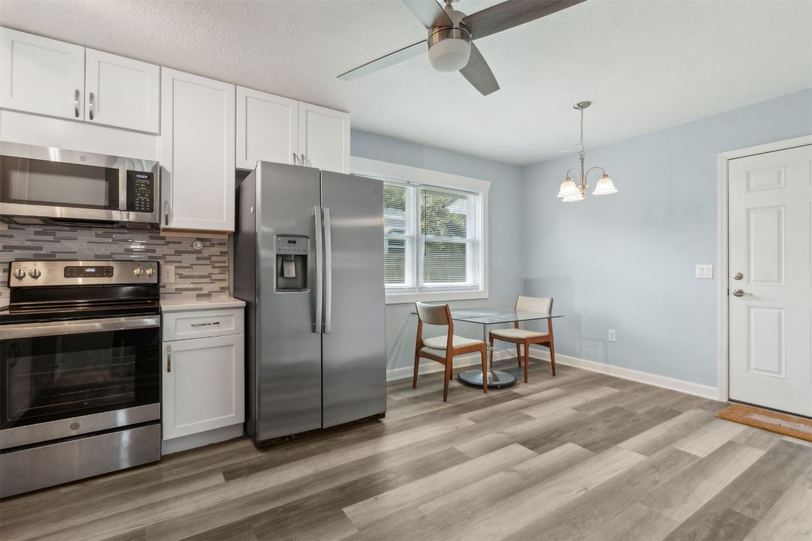 914 Jasmine Street Fernandina Beach, FL 32034 - Photo 7 of 19 a kitchen with stainless steel appliances a stove a refrigerator cabinets and wooden floor