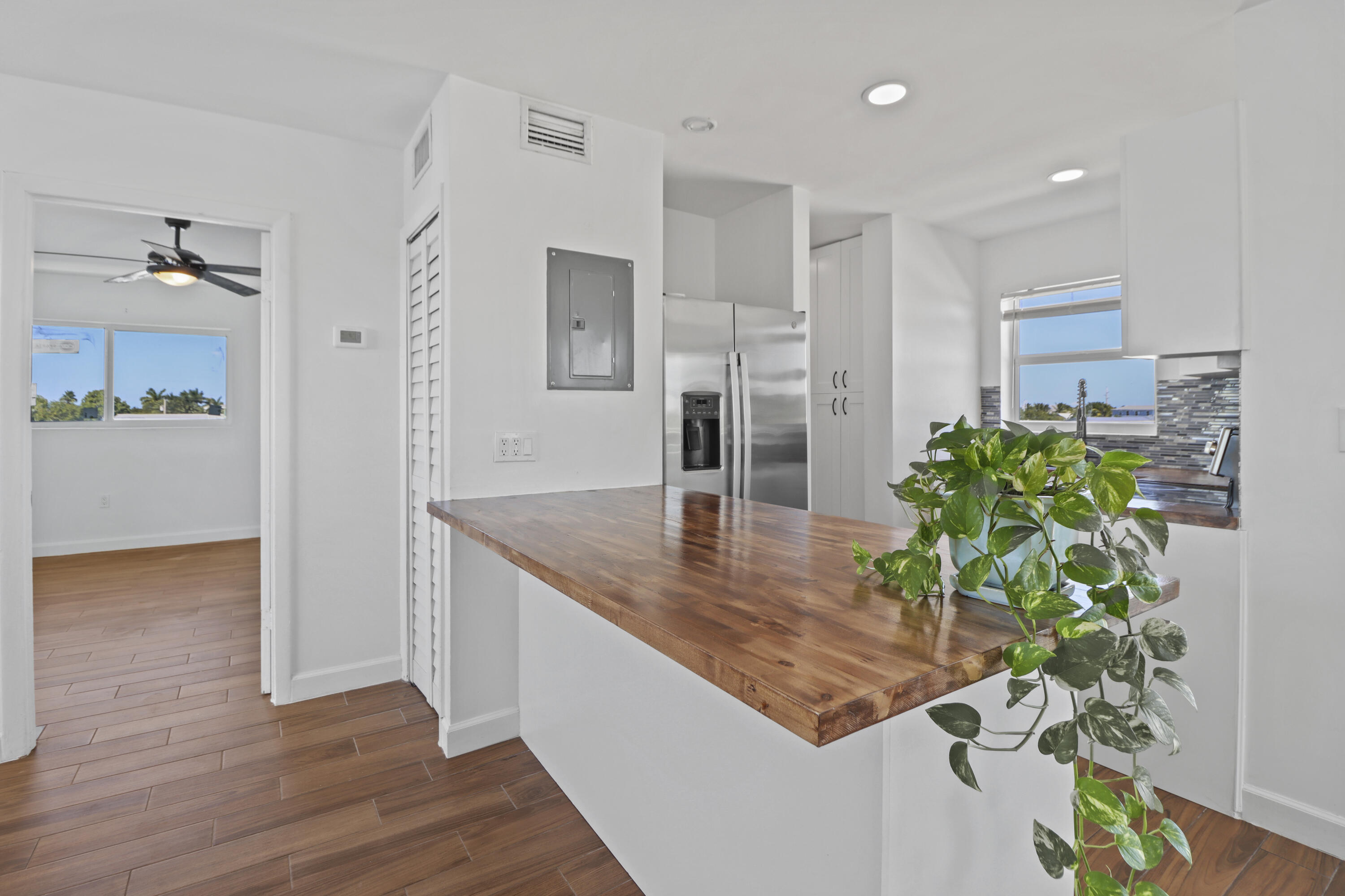 201 Coppitt Road, Unit 301A Key West, FL 33040 - Photo 6 of 25 a room with kitchen island a potted plant and wooden floor