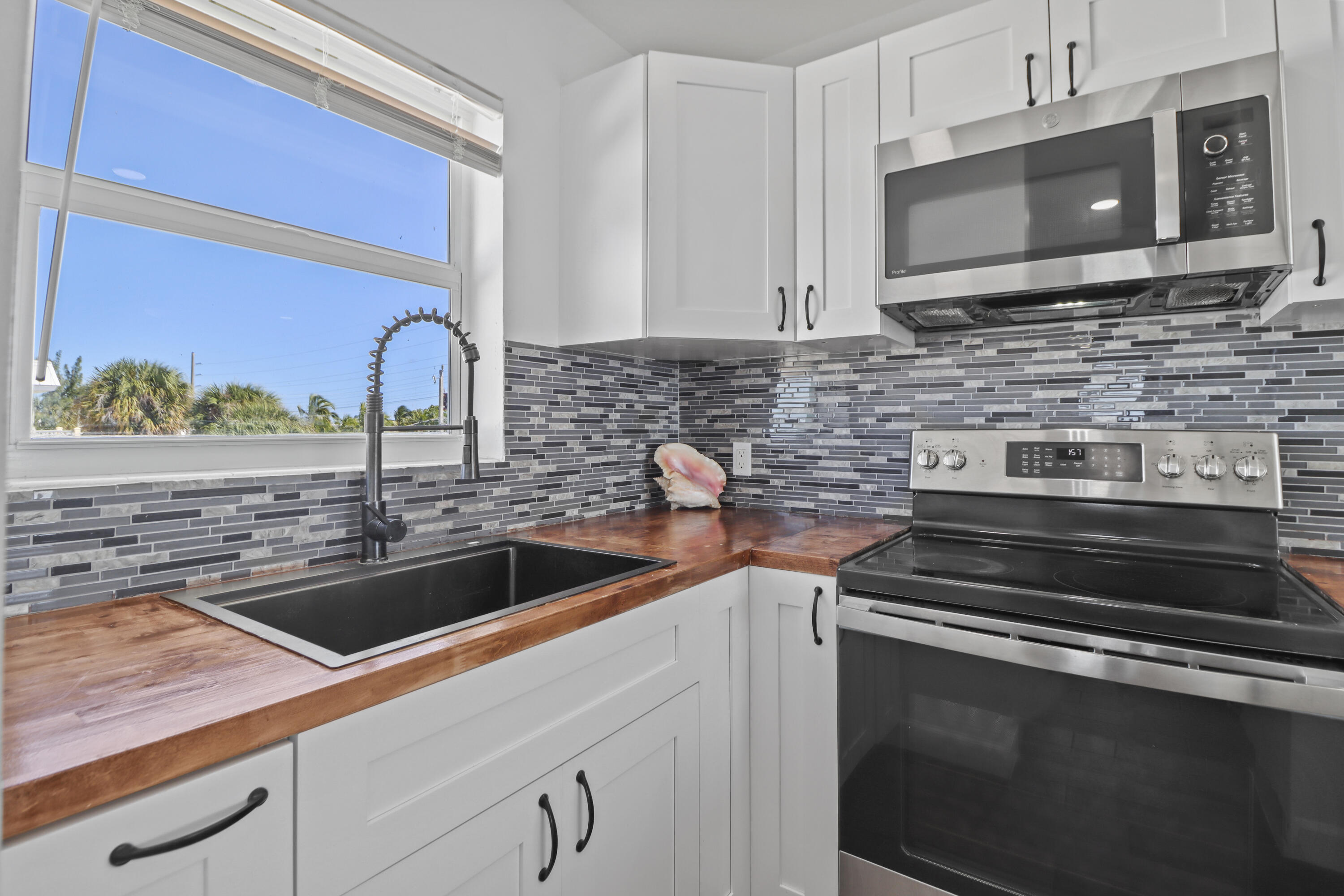 201 Coppitt Road, Unit 301A Key West, FL 33040 - Photo 8 of 25 a kitchen with stainless steel appliances a stove a microwave a sink and cabinets
