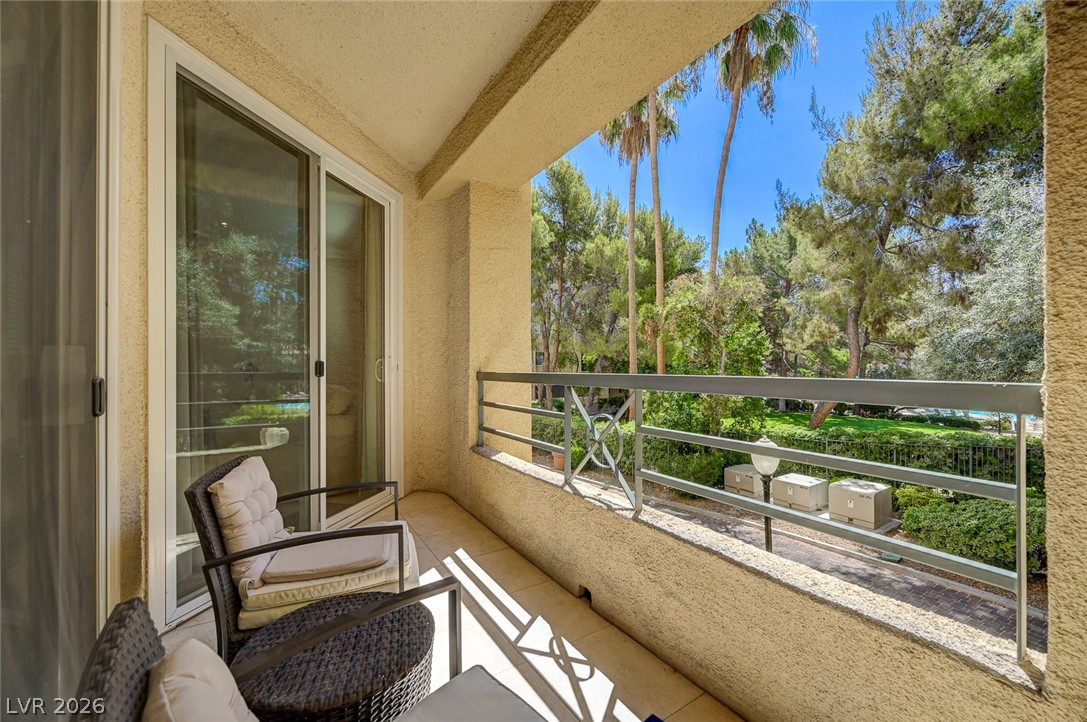 230 East Flamingo Road, Unit 106 Las Vegas, NV 89169 - Photo 24 of 66 A tranquil balcony provides a private oasis, offering a serene green view and ample space for outdoor relaxation.
