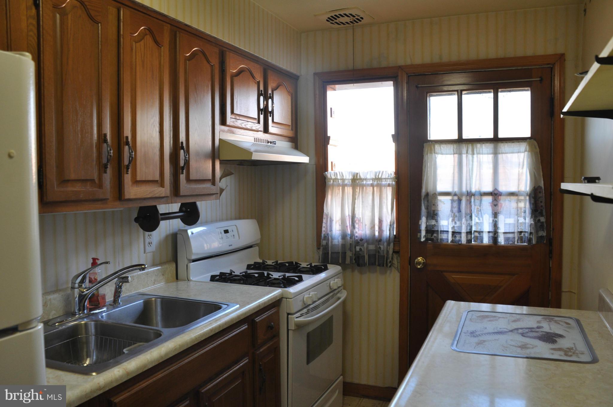 7438 Edsworth Road Baltimore, MD 21222 - Photo 6 of 12 a kitchen with a sink cabinets and a window