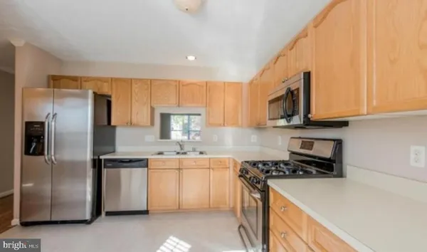 a kitchen with stainless steel appliances granite countertop a refrigerator a stove top oven a sink and dishwasher