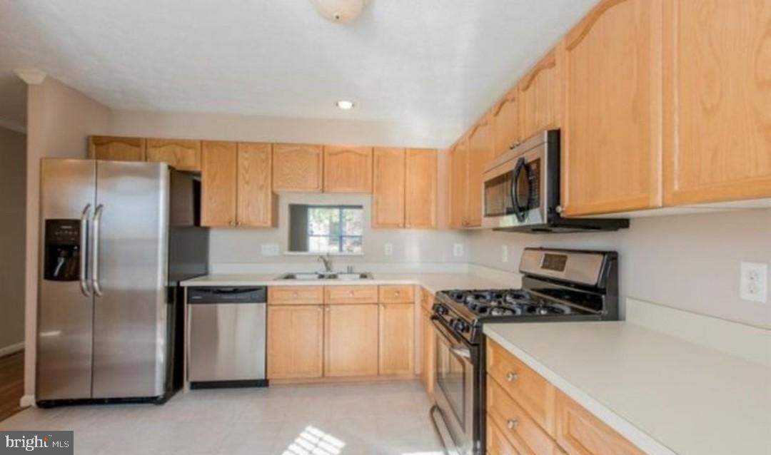 7151 Natures Road Columbia, MD 21046 - Photo 5 of 33 a kitchen with stainless steel appliances granite countertop a refrigerator a stove top oven a sink and dishwasher