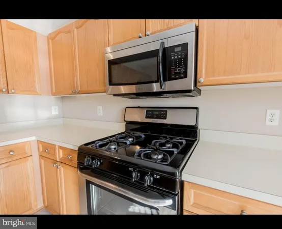 a kitchen with stainless steel appliances a stove a microwave a sink and cabinets