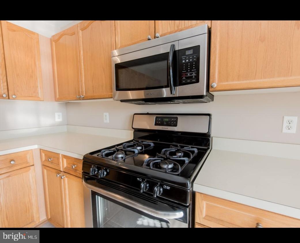 7151 Natures Road Columbia, MD 21046 - Photo 6 of 33 a kitchen with stainless steel appliances a stove a microwave a sink and cabinets