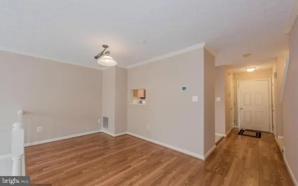 a view of a room with wooden floor and a ceiling fan