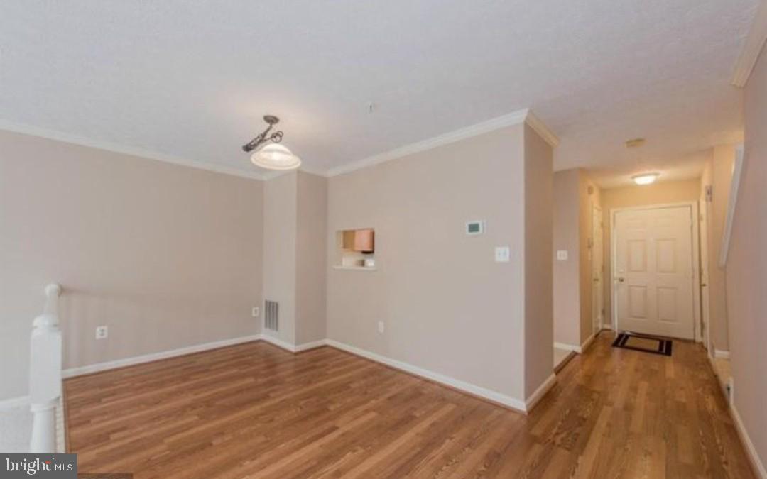 7151 Natures Road Columbia, MD 21046 - Photo 9 of 33 a view of a room with wooden floor and a ceiling fan