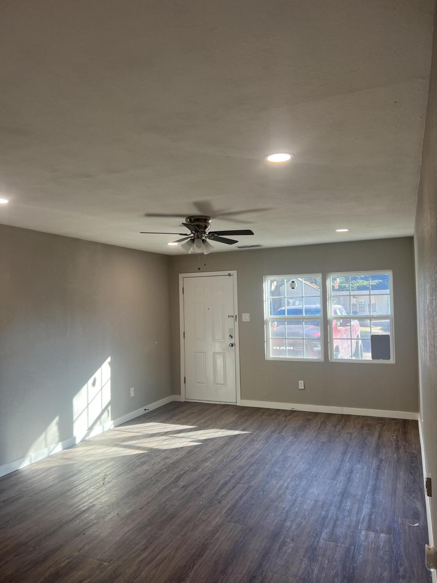 2104 22nd Street Lubbock, TX 79411 - Photo 2 of 9 an empty room with wooden floor and windows