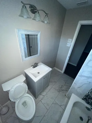 a bathroom with a sink toilet and shower