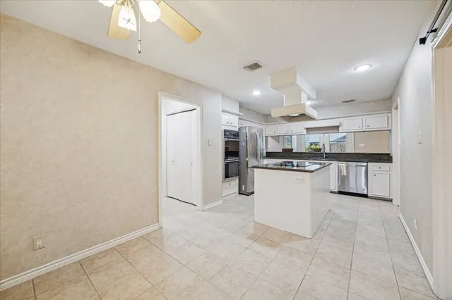 a kitchen with refrigerator and cabinets