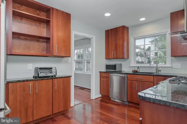 a kitchen with stainless steel appliances granite countertop wooden cabinets stove top oven and sink