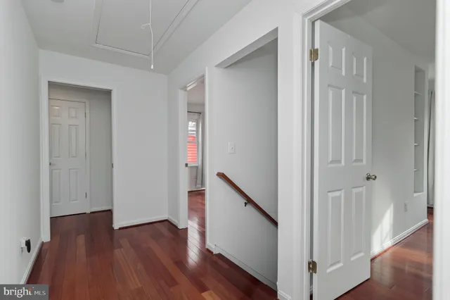 a view of a hallway with wooden floor and closet