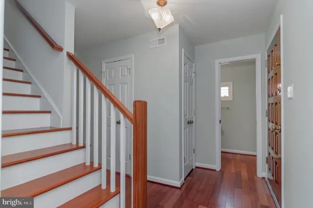 a view of a hallway with wooden floor and staircase