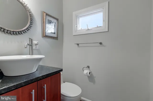 a bathroom with a toilet a sink and mirror