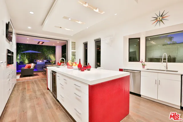 a living room with stainless steel appliances kitchen island granite countertop furniture a flat screen tv and a refrigerator