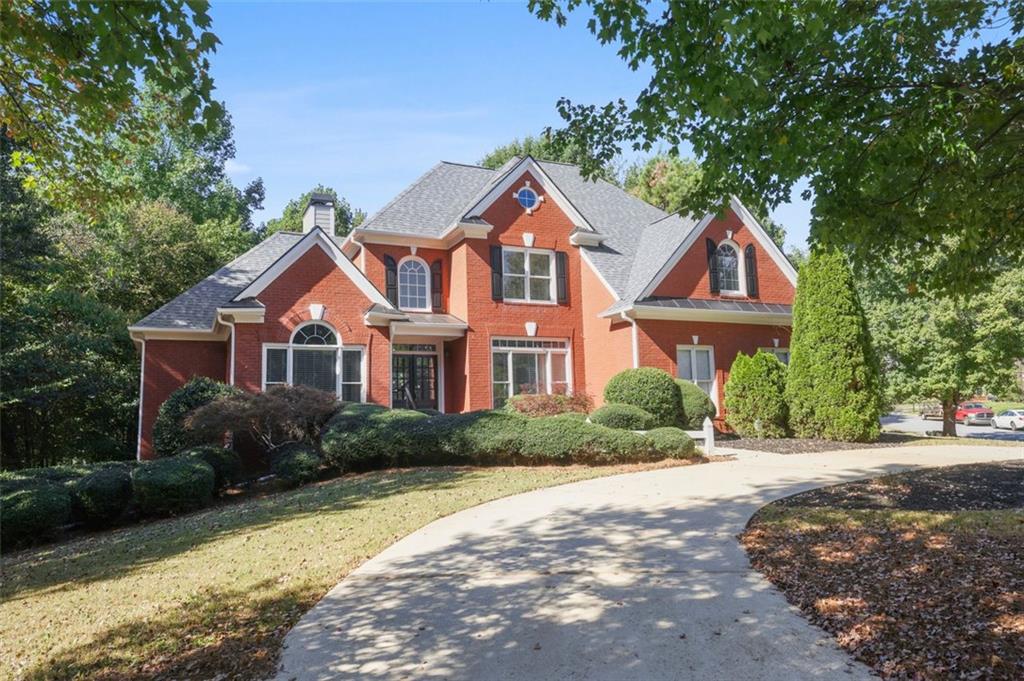 a front view of a house with a yard and trees