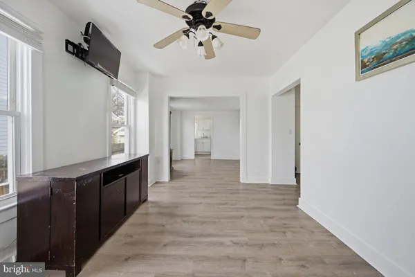 a view of an empty room with a window and wooden floor