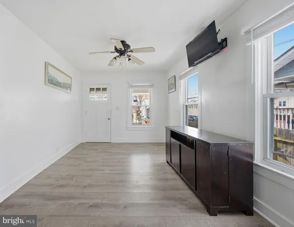 a view of a big room with wooden floor and windows