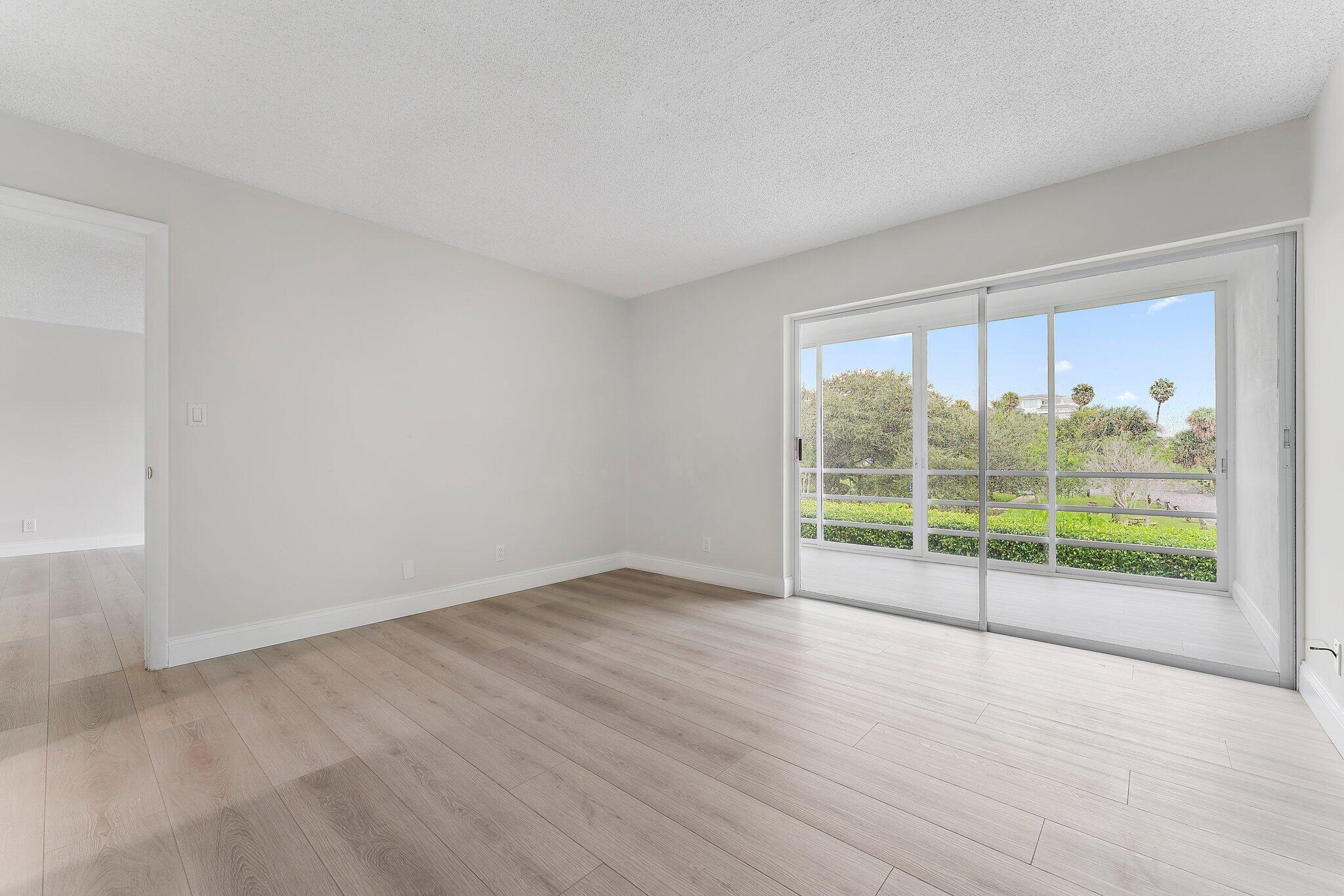 20 Celestial Way, Unit 215 Juno Beach, FL 33408 - Photo 14 of 25 an empty room with wooden floor and windows