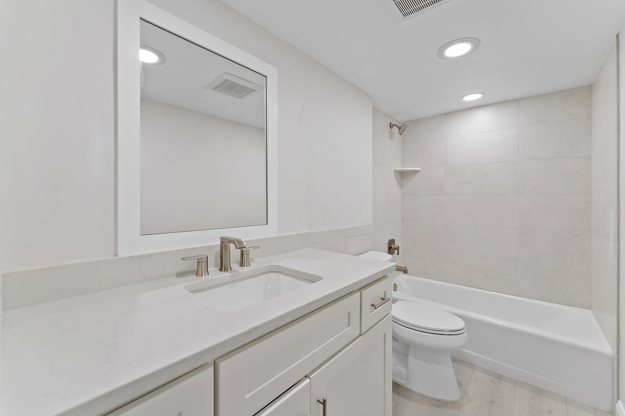 20 Celestial Way, Unit 215 Juno Beach, FL 33408 - Photo 19 of 25 a bathroom with a sink a toilet and shower